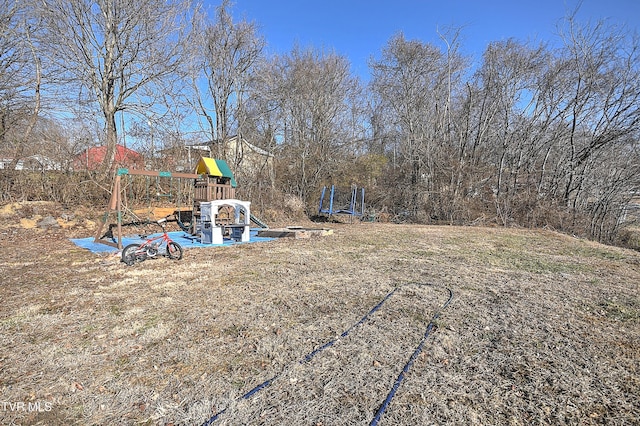 view of yard with a playground and a trampoline