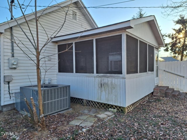 view of side of home with central air condition unit and a sunroom