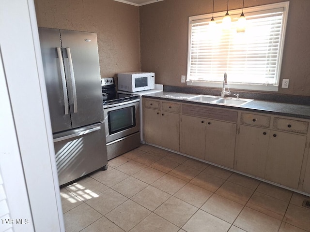 kitchen with sink, light tile patterned flooring, and stainless steel appliances