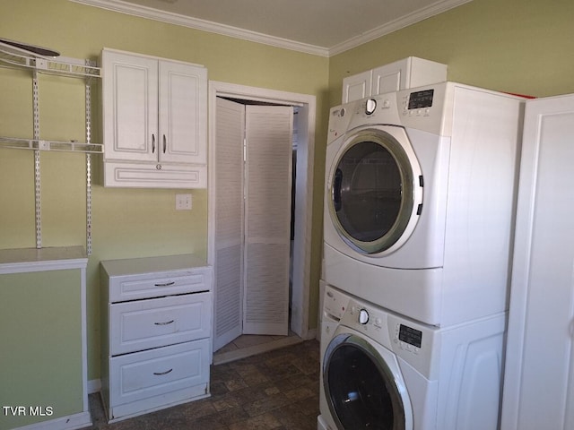 laundry room featuring stacked washer / dryer, cabinets, and crown molding