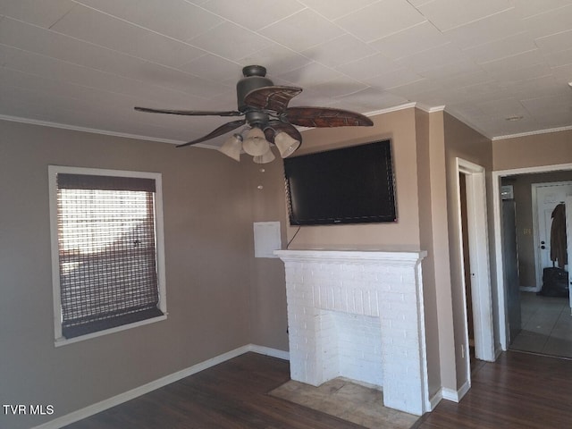 unfurnished living room featuring ceiling fan, crown molding, dark wood-type flooring, and a fireplace