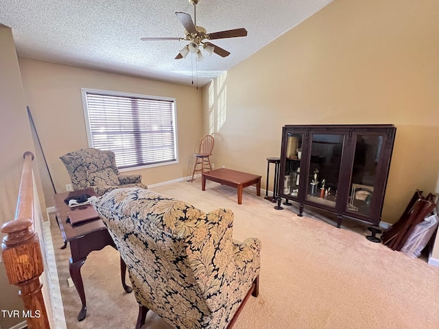 sitting room featuring ceiling fan, a textured ceiling, light carpet, and vaulted ceiling