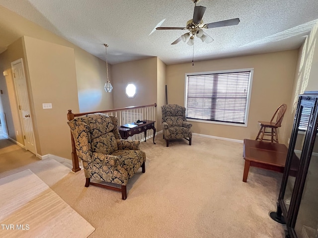 sitting room with ceiling fan, a textured ceiling, and carpet flooring