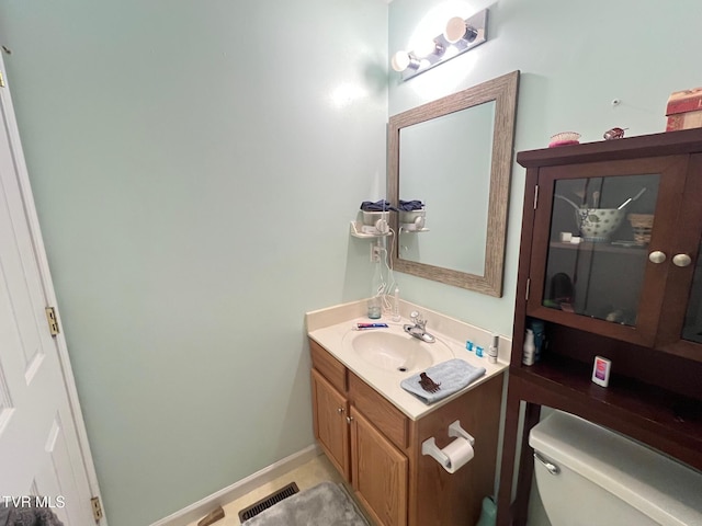 bathroom featuring toilet, vanity, and tile patterned flooring