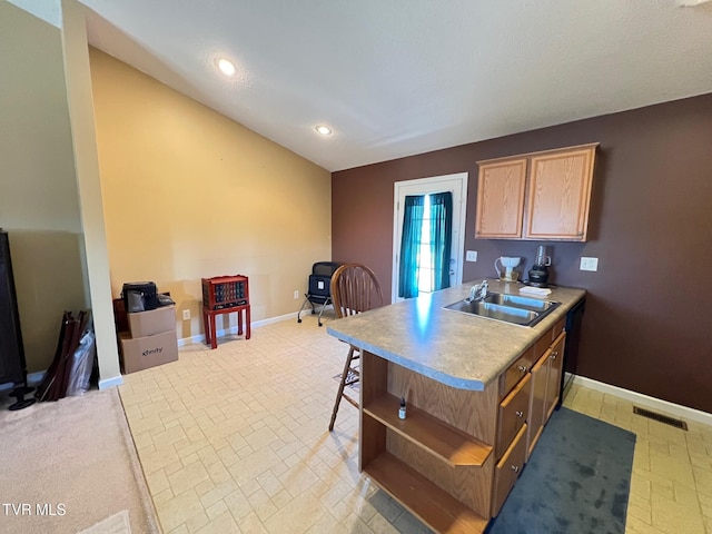 kitchen with sink, dishwashing machine, and a kitchen bar