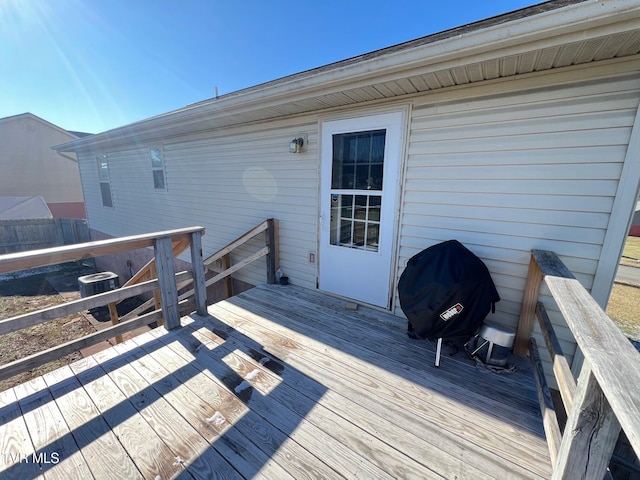 wooden deck featuring cooling unit and a grill