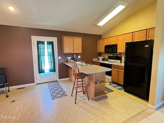 kitchen featuring a center island, lofted ceiling, black appliances, a kitchen breakfast bar, and sink