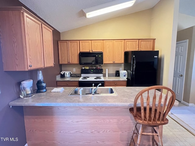 kitchen featuring black appliances, lofted ceiling, sink, kitchen peninsula, and a breakfast bar area