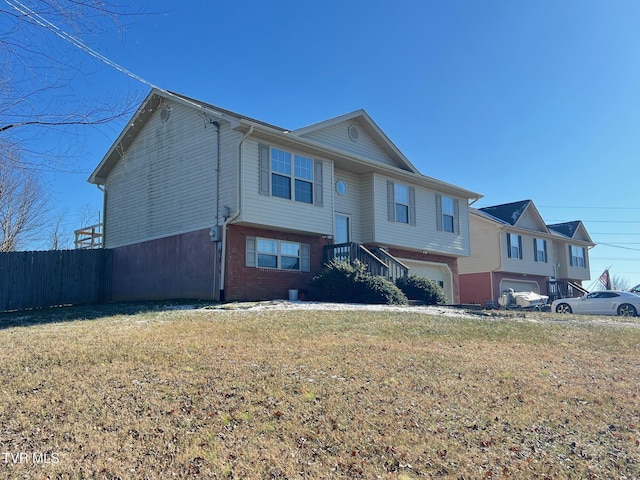 bi-level home with a garage and a front yard