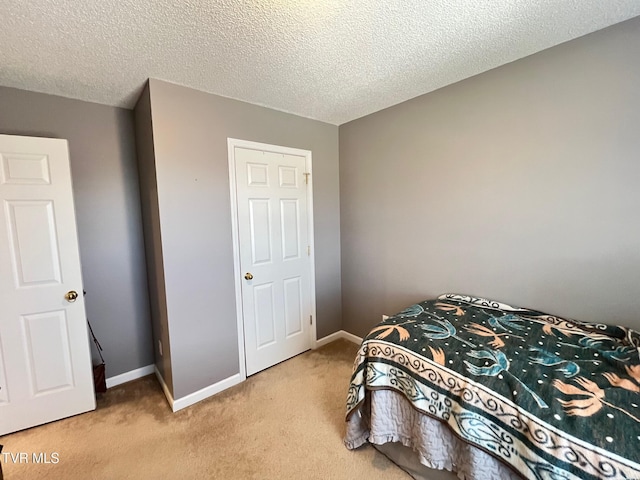 bedroom featuring light colored carpet and a textured ceiling