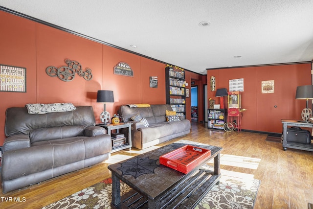 living room featuring crown molding, light hardwood / wood-style floors, and a textured ceiling