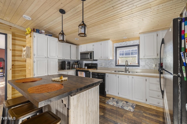 kitchen with butcher block countertops, sink, decorative light fixtures, black appliances, and white cabinets