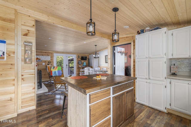 kitchen with hanging light fixtures, french doors, white cabinets, and a kitchen island