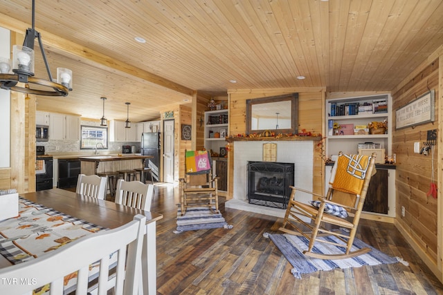 dining area featuring dark hardwood / wood-style floors, vaulted ceiling with beams, and wooden walls