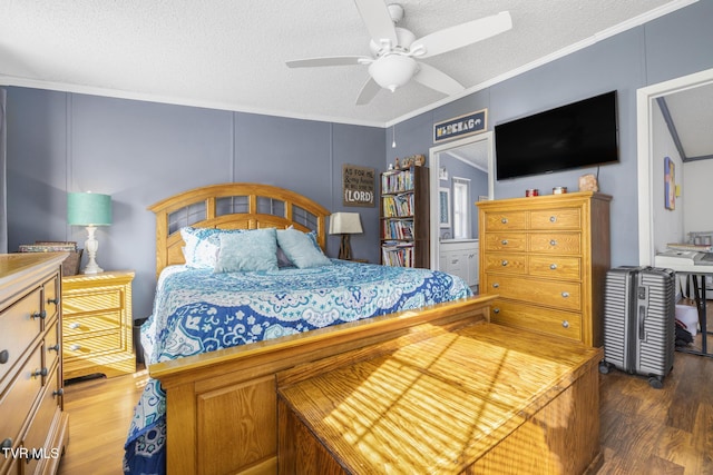 bedroom with dark wood-type flooring, ceiling fan, ornamental molding, and a textured ceiling