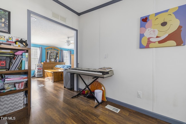 miscellaneous room featuring dark wood-type flooring, ceiling fan, ornamental molding, and a textured ceiling