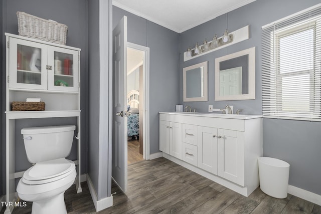 bathroom featuring vanity, hardwood / wood-style floors, ornamental molding, and toilet