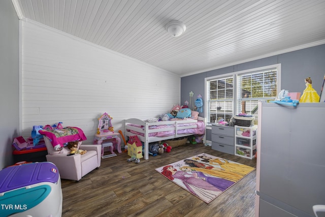 bedroom with dark wood-type flooring, ornamental molding, and lofted ceiling