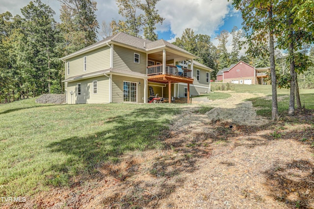 rear view of house with a wooden deck and a yard