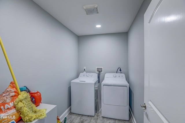 clothes washing area featuring light hardwood / wood-style flooring and washing machine and clothes dryer