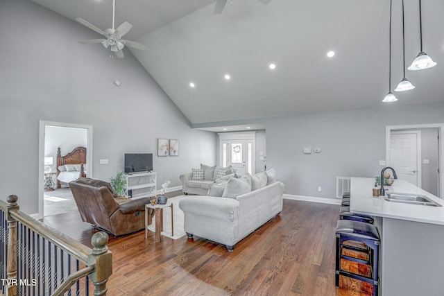 living room featuring dark wood-type flooring, sink, high vaulted ceiling, and ceiling fan