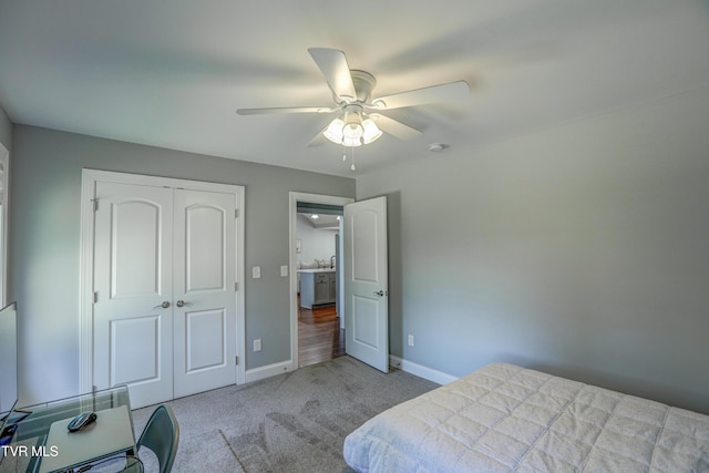 bedroom with a closet, ceiling fan, and light carpet