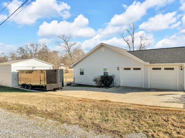 view of side of property featuring a garage and a lawn