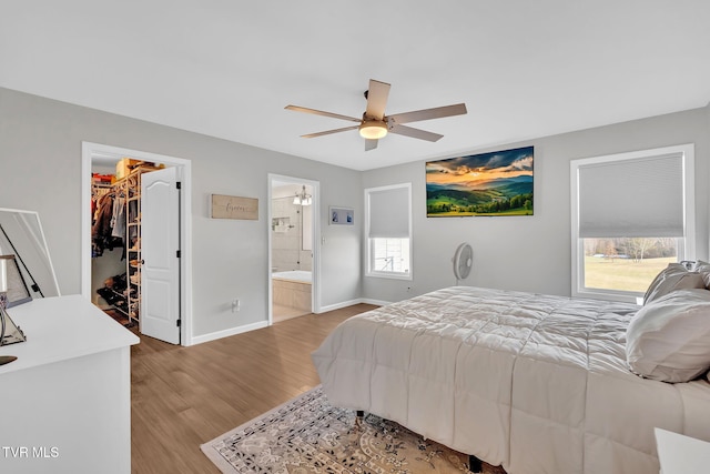 bedroom featuring ceiling fan, hardwood / wood-style floors, connected bathroom, a spacious closet, and a closet