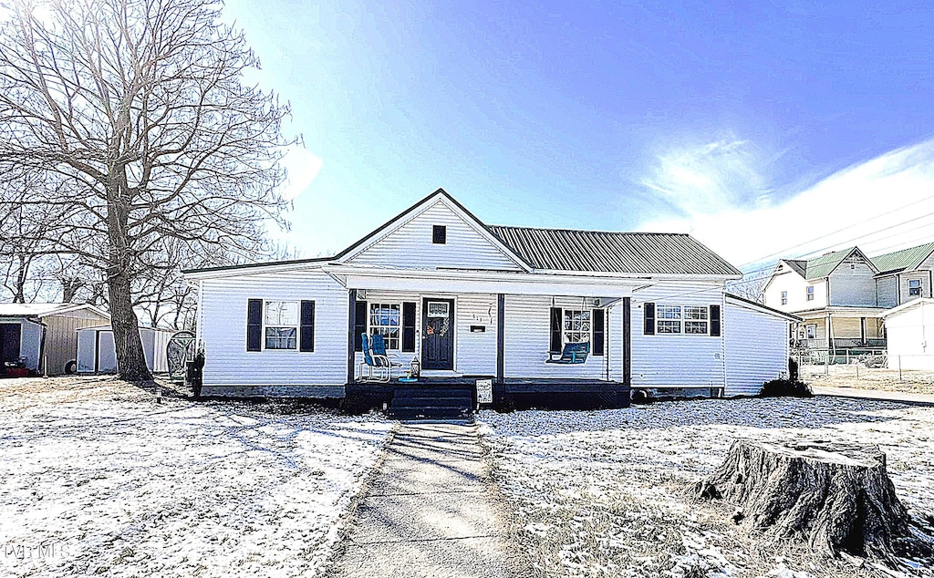 view of front of home with metal roof and a porch