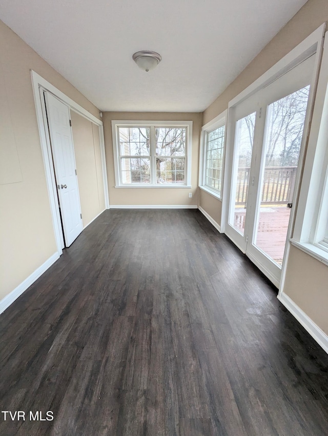 interior space featuring plenty of natural light and dark hardwood / wood-style floors