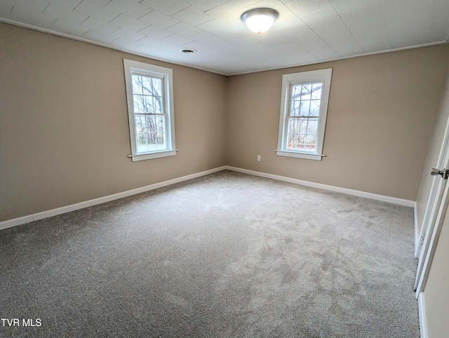 unfurnished room featuring plenty of natural light and carpet