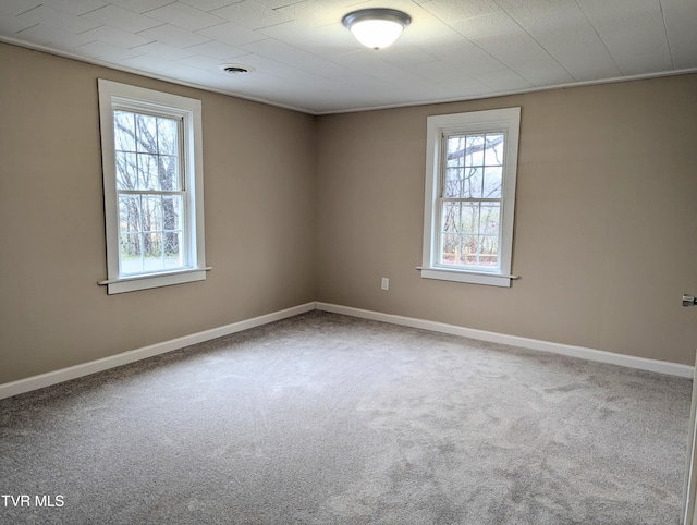 unfurnished room featuring a wealth of natural light and carpet