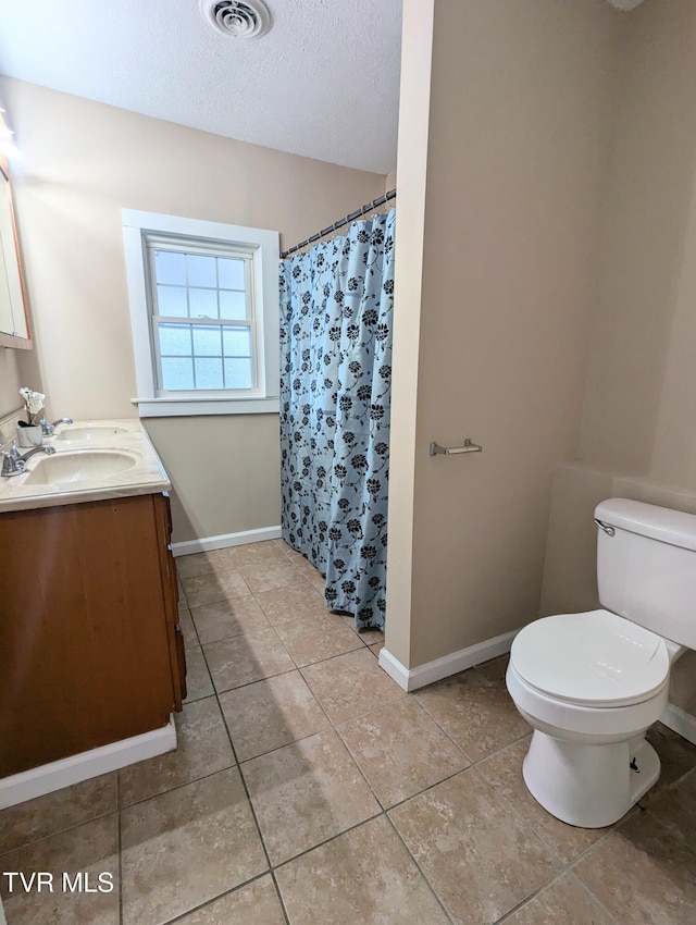 bathroom featuring a textured ceiling, toilet, a shower with shower curtain, and vanity