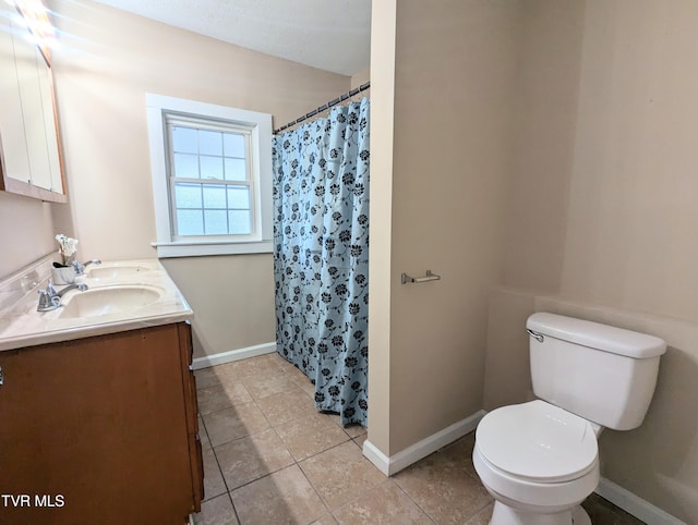 bathroom featuring toilet, tile patterned flooring, walk in shower, and vanity