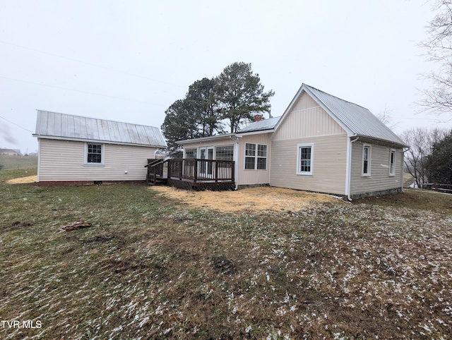 rear view of house with a deck and a yard