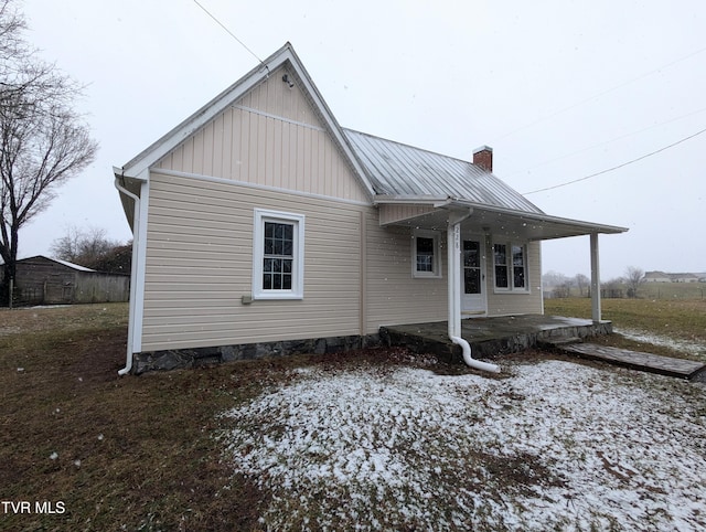 view of snow covered back of property