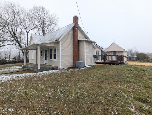 view of side of home featuring central AC unit, a wooden deck, and a yard