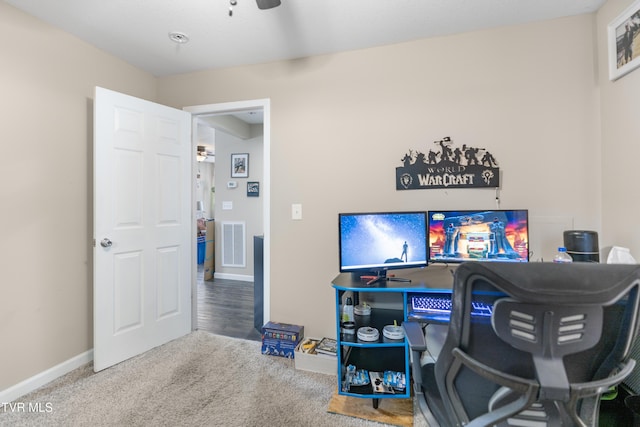 carpeted home office featuring ceiling fan