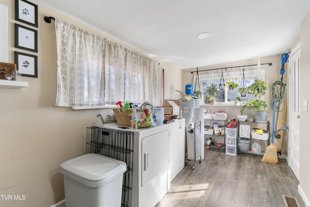 clothes washing area with washer and dryer and hardwood / wood-style floors