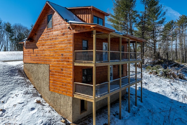 snow covered property featuring a balcony