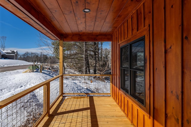 snow covered deck featuring a porch