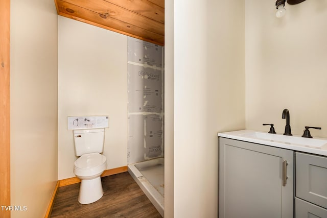 bathroom with hardwood / wood-style flooring, vanity, toilet, and a shower