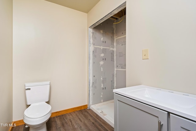 bathroom with wood-type flooring, vanity, and toilet