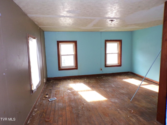 unfurnished room featuring dark hardwood / wood-style flooring and a textured ceiling