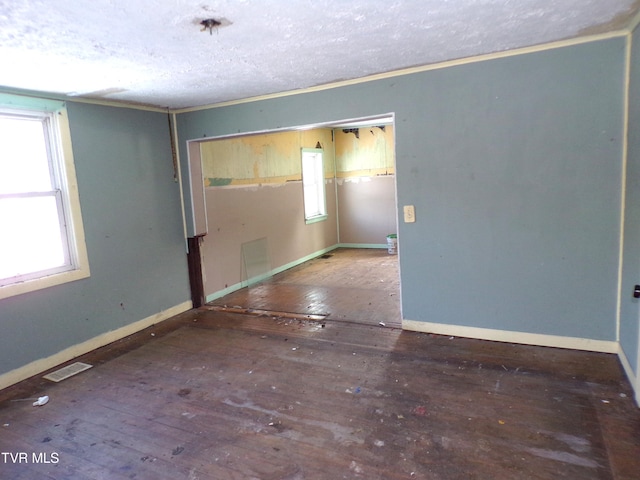 unfurnished room with hardwood / wood-style flooring and a textured ceiling