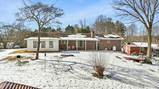 view of snow covered back of property