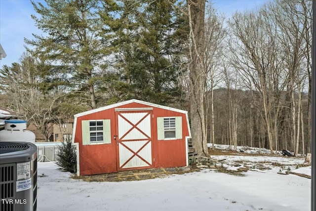 snow covered structure with central air condition unit