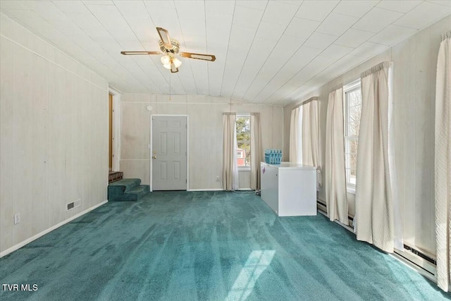 empty room with ceiling fan, plenty of natural light, and carpet flooring