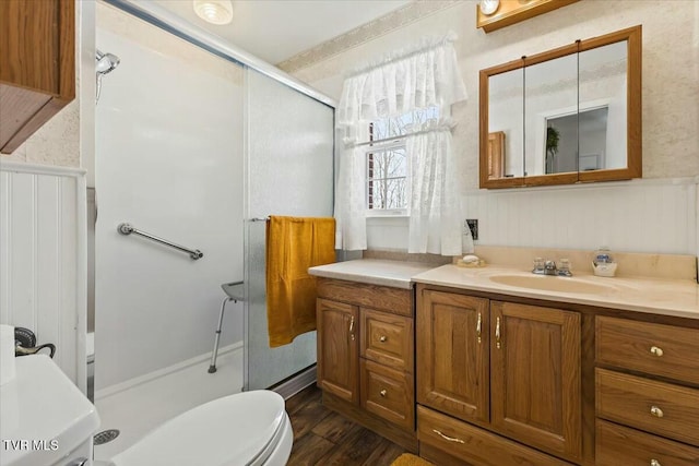 bathroom featuring wood-type flooring, toilet, an enclosed shower, and vanity