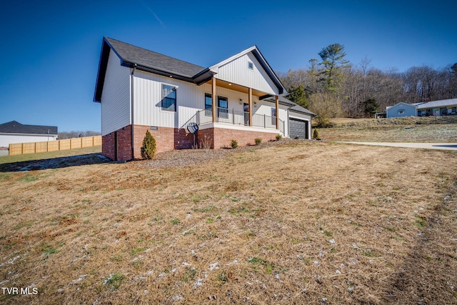 view of front of home with a garage, a front yard, and a porch